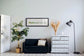 Aquarela do Parque Ibirapuera com moldura preta, pendurada na parede de uma sala de estar